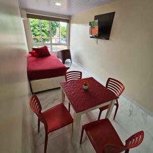 um quarto com duas camas e uma mesa e cadeiras em Mensú Grand Hotel em Puerto Iguazú