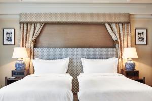 - 2 lits dans une chambre d'hôtel avec 2 lampes dans l'établissement De L’Europe Amsterdam – The Leading Hotels of the World, à Amsterdam