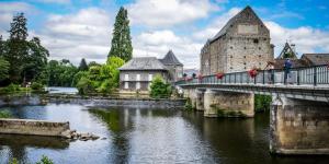 a bridge over a river in front of a castle at MAISON AU COEUR DE LA PETITE CITE DE CARACTERE in Malestroit