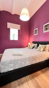 een slaapkamer met paarse muren en een groot bed bij New Camp Nou Apartment/Diret Airport,Beautiful in Hospitalet de Llobregat