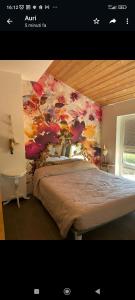 een slaapkamer met een bed met een schilderij aan de muur bij VILLA DELLE ROSE CINQUE TERRE in Beverino