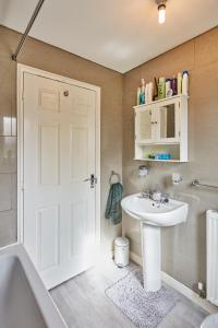 a bathroom with a white sink and a shower at A modern home away from home in Killingbeck