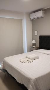 un lit blanc avec une serviette blanche dessus dans l'établissement Veneto Village, Complejo Vacacional, à Villa Parque Siquiman