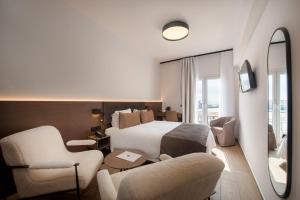 una camera d'albergo con letto e sedia di Lesvion Hotel a Mytilini