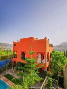 an orange house with a tree in front of it at Riad Vallée Verte Asni in Asni