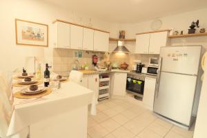 a kitchen with white cabinets and a white refrigerator at A Dream Place in Raanana, up to 5 guests - Swimming Pool - Jacuzzi & Gym in Ra‘ananna