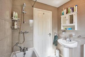 a bathroom with a shower and a sink and a toilet at A modern home away from home in Killingbeck