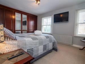 a bedroom with a bed and a tv on the wall at Pass the Keys Elegant Home near Cotswolds in Evesham