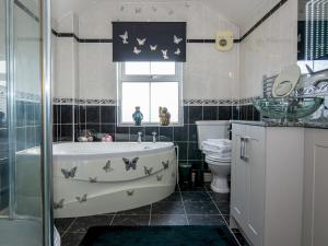 a bathroom with a bath tub and a toilet at Pass the Keys Elegant Home near Cotswolds in Evesham