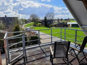 a balcony with a railing and two chairs and a view at Prins van Poederoijen in Poederoijen