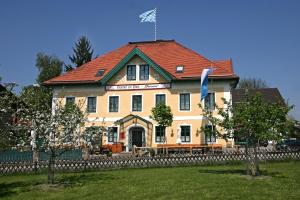 a large yellow house with a red roof at Gasthof zur Post Oberwirt in Chieming