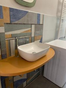 a white sink on a table in a bathroom at L’appartamento di Mango e Pistacchio in Segrate