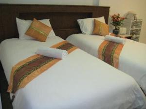dos camas blancas sentadas una al lado de la otra en una habitación en Lamai Perfect Resort, en Lamai