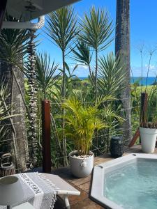 a hot tub on a deck with palm trees at Indigo Palmes in Sainte-Rose