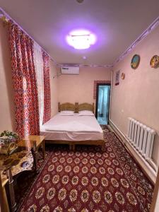 een slaapkamer met een bed in een kamer bij ''NAVO'' Guest House in Bukhara