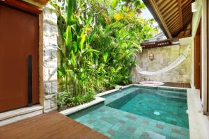 スミニャックにあるAksari Villa Seminyak by Ini Vie Hospitalityの庭園付きの家の中のスイミングプール