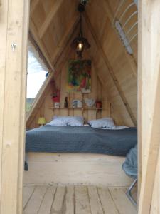 a bed in the middle of a room in a tree house at Altana letnia nr1 - Herbergerówka Agroturystyka na wsi in Duszniki Zdrój