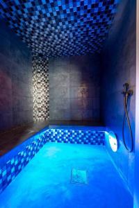 a swimming pool in a room with a shower at La Clé du Bonheur sauna jacuzzi hammam massages 