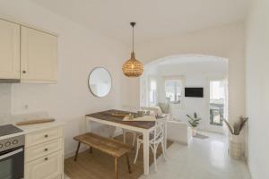 a white kitchen with a table and a dining room at Piperi-2 Bedroom home in Naousa