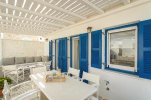 a patio with blue shutters and a table and chairs at Piperi-2 Bedroom home in Naousa