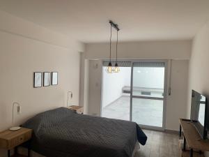 a bedroom with a bed and a sliding glass door at Luminoso monoambiente en Rosario in Rosario