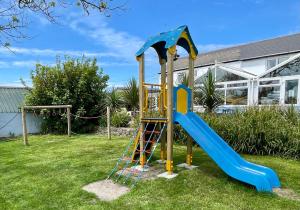 a playground with a slide in a yard at Roselands Caravan Park in St. Just