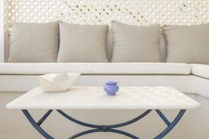 a white couch with a white table with a blue vase on it at Piperi-2 Bedroom home in Naousa