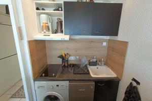 una pequeña cocina con fregadero y lavadora en Very functional apartment with sea view, en Bandol