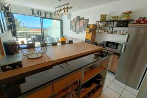 cocina con encimera de madera y nevera en Very functional apartment with sea view, en Bandol