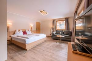 a hotel room with a bed and a couch at Hotel Acherl in Achenkirch