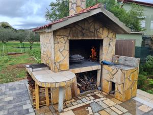 een stenen oven met een tafel en een grill bij Apartments Bosnjak in Šibenik