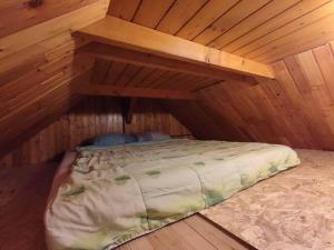 an attic room with a bed in a wooden room at Beehive cabin on a farm in Radovljica