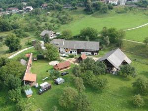 une vue aérienne sur une maison avec des voitures garées dans un champ dans l'établissement Beehive cabin on a farm, à Radovljica