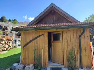 un cobertizo de madera con una puerta en un patio en Beehive cabin on a farm, en Radovljica