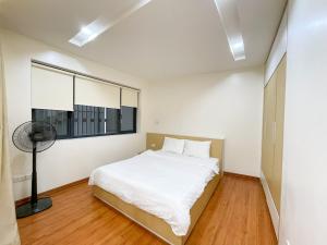 sypialnia z białym łóżkiem i oknem w obiekcie NINE HOUSING 92 Dao Tan w mieście Hanoi