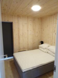 Captains Cottage في Sandur: سريرين في غرفة بجدران خشبية