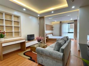 a living room with a couch and a bed at NINE HOUSING 92 Dao Tan in Hanoi