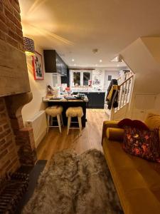 Luxury 2 bed cottage in the centre of Melbourne في ملبورن: غرفة معيشة مع أريكة ومطبخ