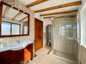 a bathroom with a sink and a glass shower at Podere Il Ritorno in Portoferraio