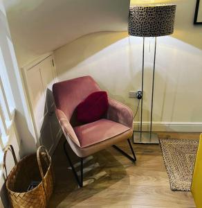 - Silla rosa con almohada roja en la habitación en Luxury 2 bed cottage in the centre of Melbourne en Melbourne