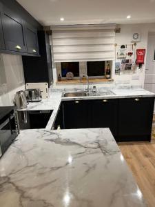 uma cozinha com armários pretos e um balcão de mármore em Luxury 2 bed cottage in the centre of Melbourne em Melbourne