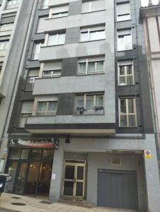 un edificio alto gris con ventanas y garaje en Centro-GASCONA con terraza, garaje y wifi gratuito, en Oviedo