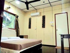 a bedroom with a bed and a window and a mirror at Sukau Backpackers B&B in Sukau