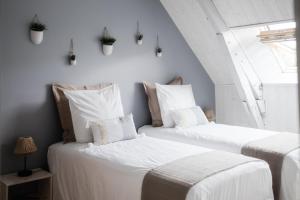 two white beds in a room with a window at Le moulin des Forges in Sainte-Suzanne