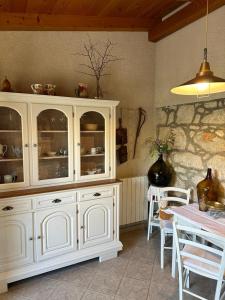 a kitchen with a white hutch and a table with chairs at Apartments Gabri in Mali Lošinj
