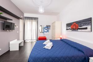 Un dormitorio con una cama azul con toallas. en Il Vittoria - Self Check in, en Lascari