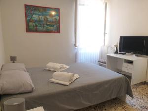 a bedroom with a bed and a desk with a television at SENZATESTA 2 in Osimo