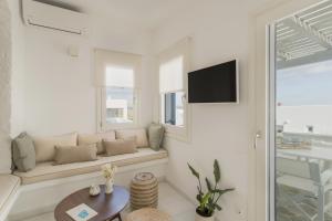 a white living room with a couch and a table at Piperi-2 Bedroom home in Naousa