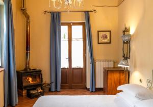 a bedroom with a bed with blue curtains and a fireplace at Borgo I Tre Baroni - Spa Suites & Resort in Poppi