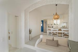 a white living room with a couch and a kitchen at Piperi-2 Bedroom home in Naousa